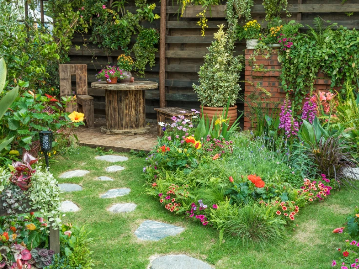 A vibrant garden featuring a stone path winding through colorful flowers.