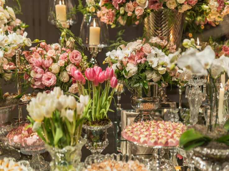 A colorful table filled with various flowers and an assortment of candies, creating a cheerful and festive display.