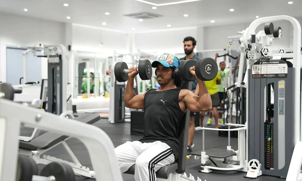 Peeacelily | Planet Fitness: Membership Costs, Equipment, Benefits, and What to Know Man lifting dumbbells in a seated shoulder press exercise to build upper body muscle