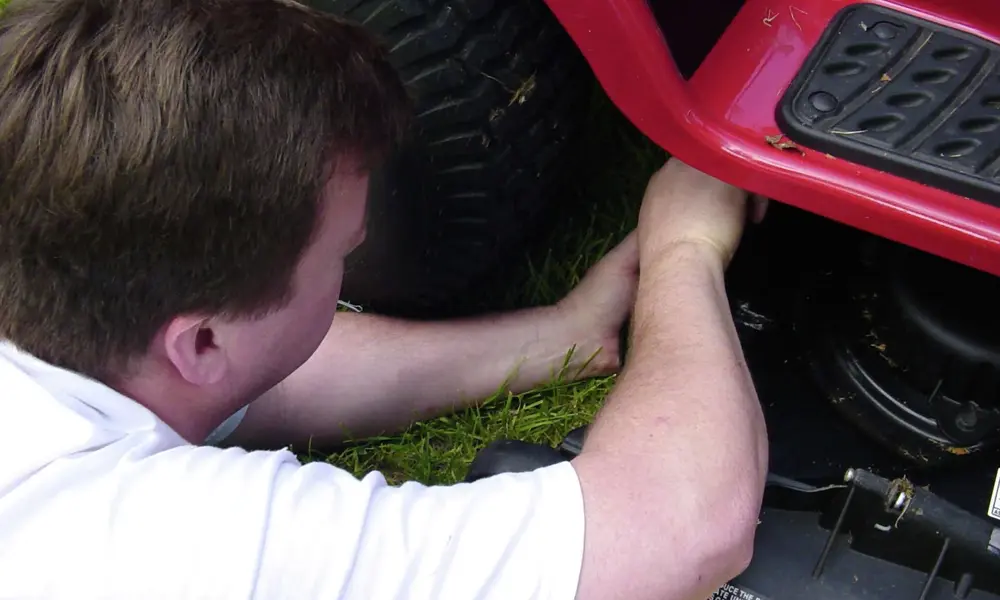 Peeacelily | Lawn Mower Repair: Common Problems and How to Fix Them Close-up of an orange Husqvarna lawn mower engine with a red arrow pointing toward the air filter housing.