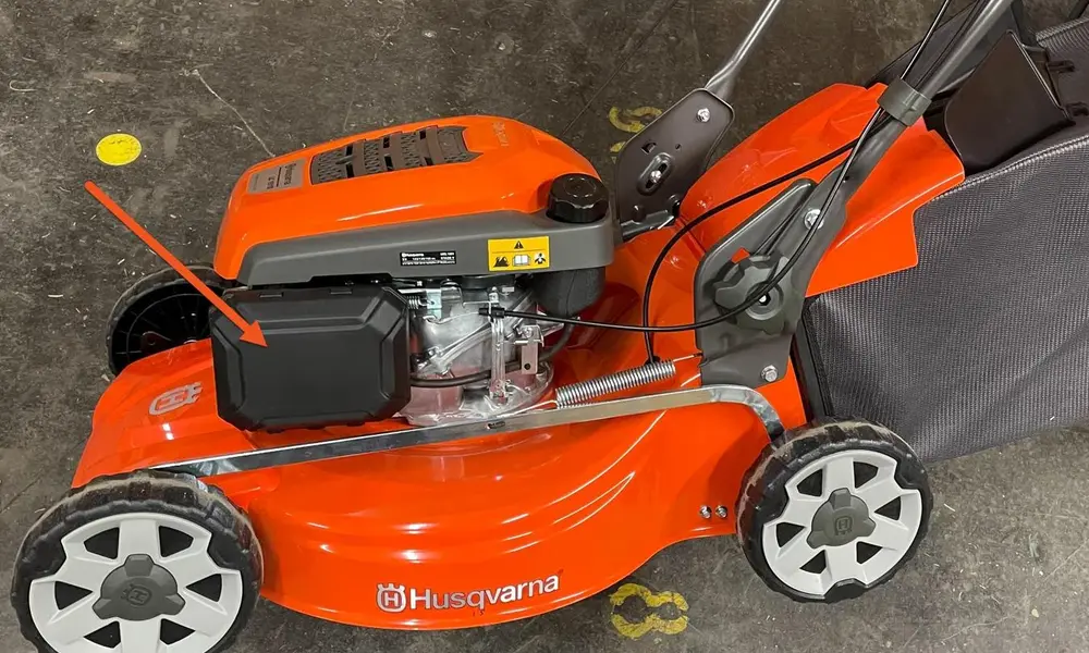 Peeacelily | Lawn Mower Repair: Common Problems and How to Fix Them A person inspecting the underside and blade assembly of a red lawn mower resting on grass.