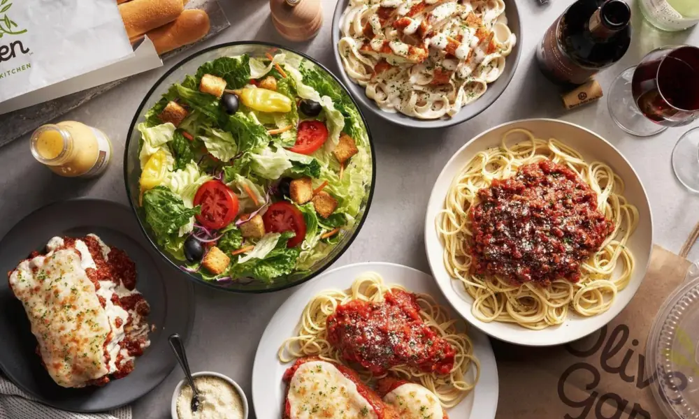 Peeacelily | Olive Garden: A Guide to the Menu, Dining, and Ordering Overview flatlay of classic Olive Garden menu items showing salad, spaghetti, lasagna, and breadsticks