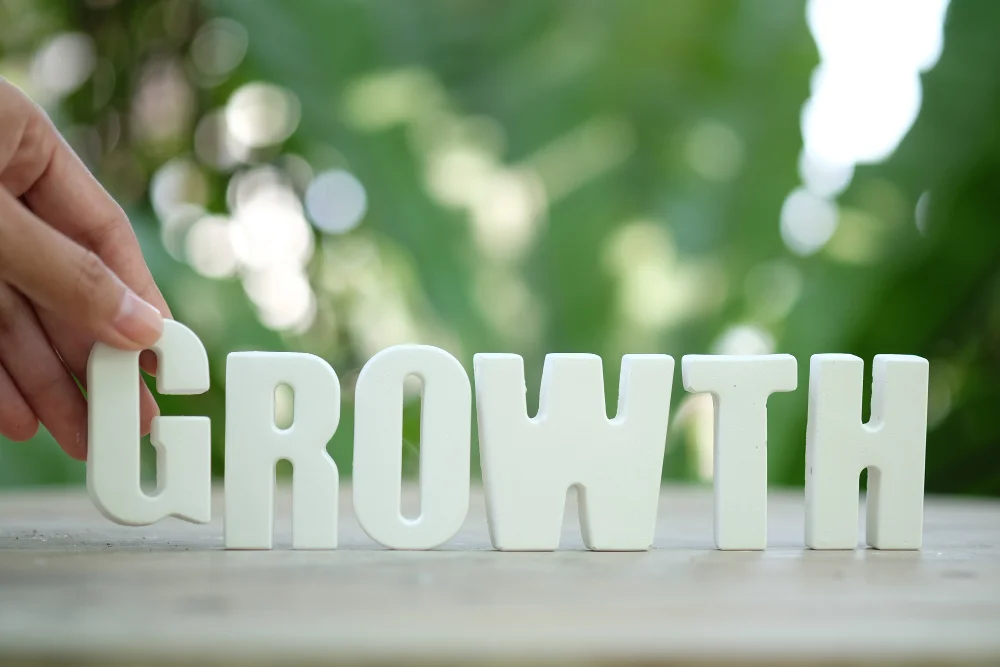 Hand arrange white letters as growth